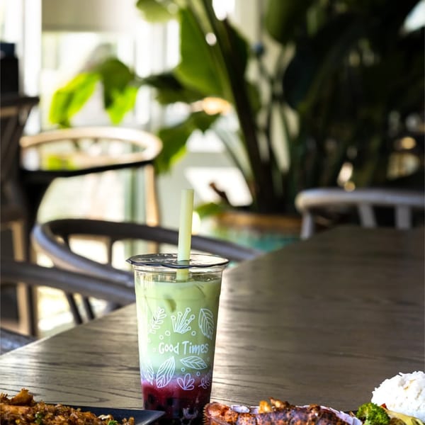 Spread of fried rice, lobster and a matcha boba drink on a wooden table