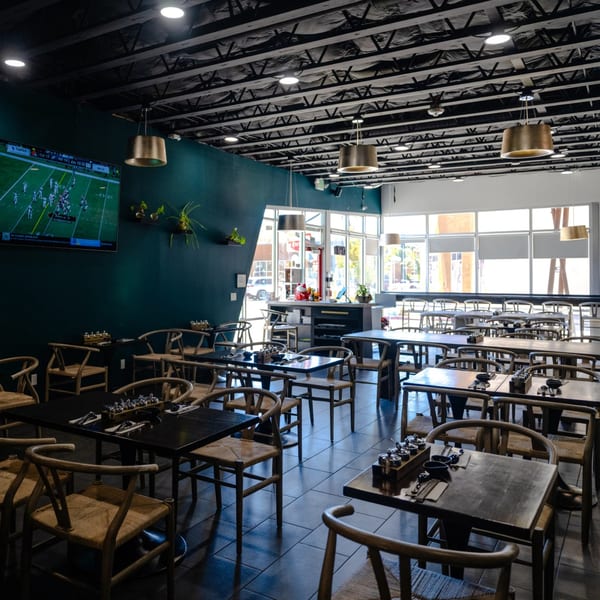 Dining room with a football game on the TV and green accent wall