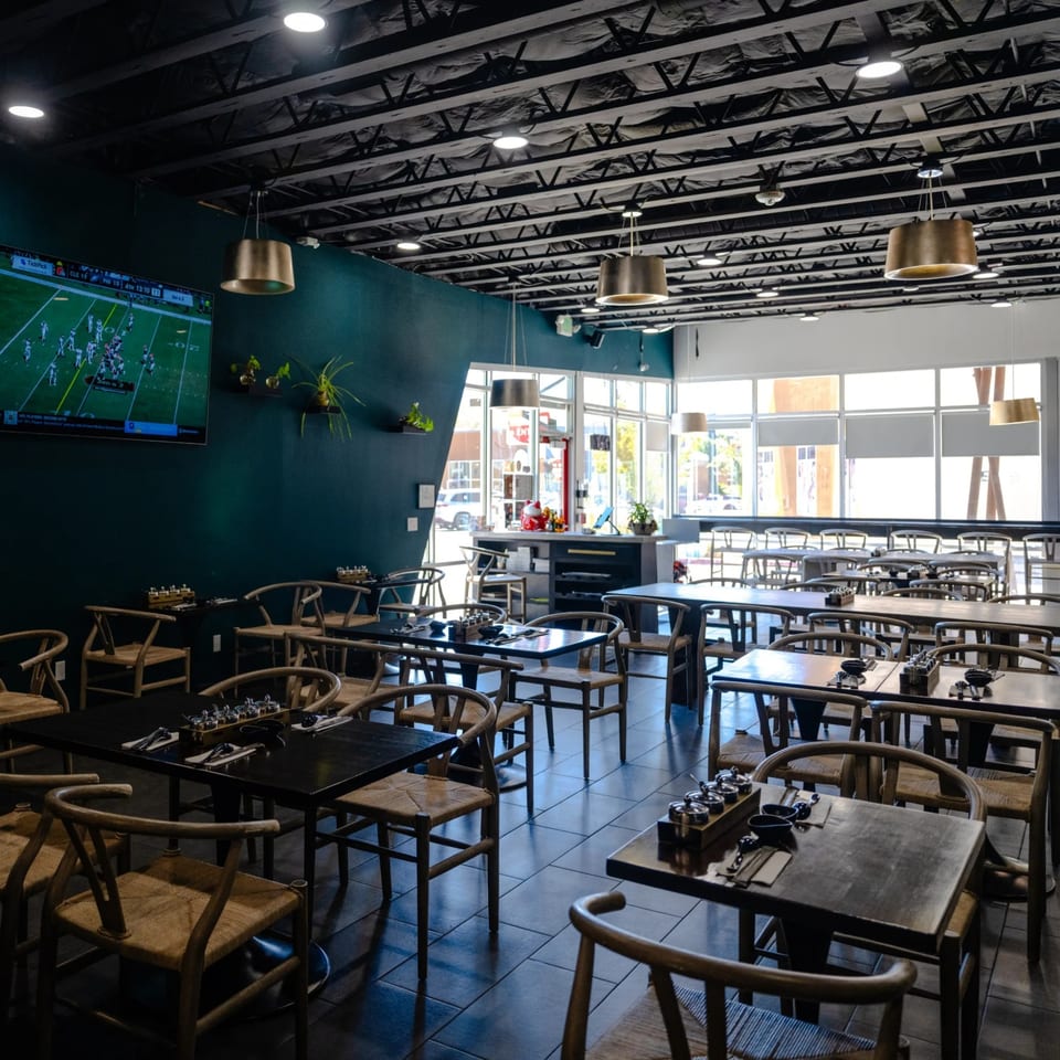 Dining room with a football game on the TV and green accent wall